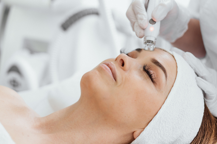 A professional esthetician uses the RF Lifting procedure to rejuvenate and tighten the skin of the client's face. Vacuum Facial Massage for Woman's Skin Care. High quality photo